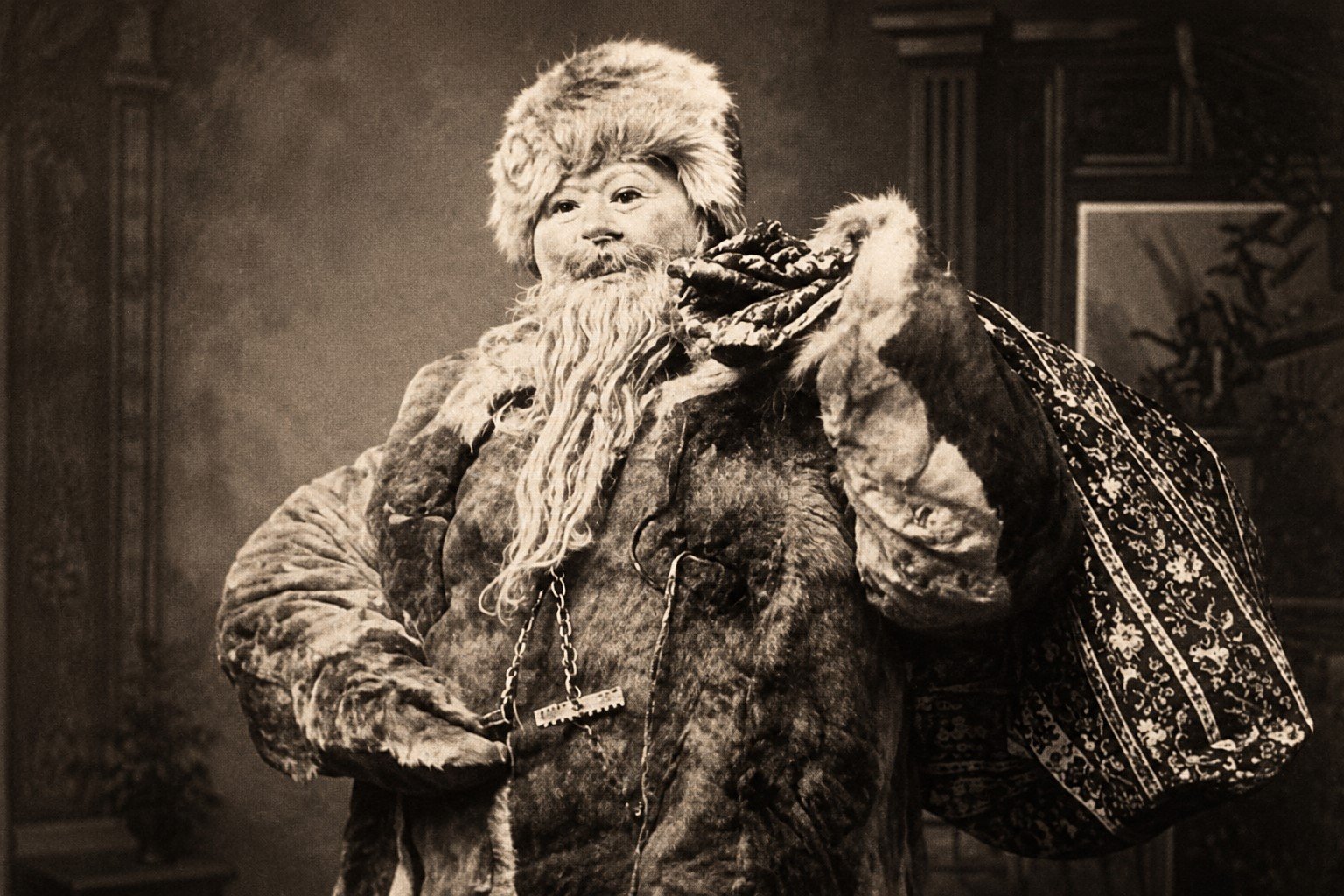 A vintage photograph of a figure dressed as an unsettling Santa Claus, wearing fur and carrying a patterned sack, evoking the darker folklore of Christmas.