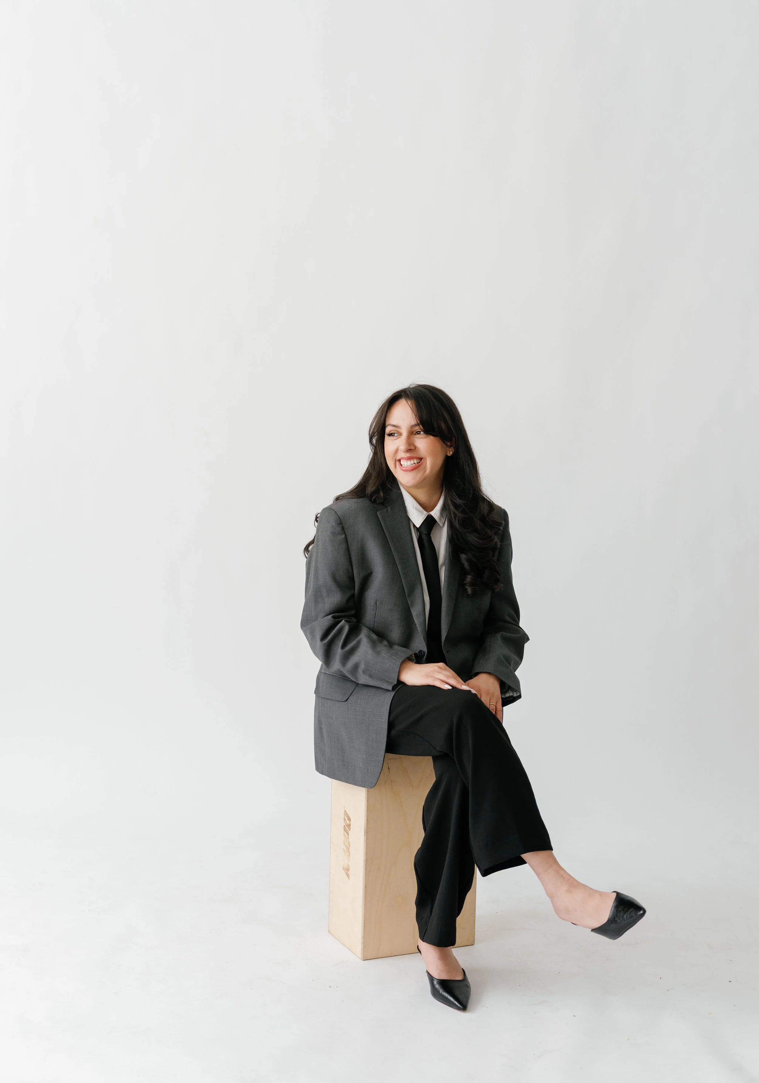 NYC calligrapher and hand engravgin artist Karina Vellon of Penned by K sitting in modern studio portrait