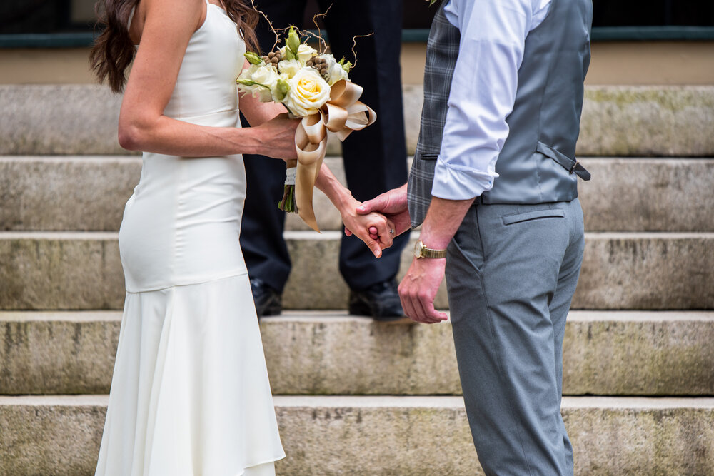 Bride and Groom holding hands during their wedding ceremony at the Inn on Montford
