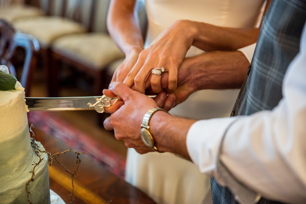 Bride and Groom's hands on the cake knife by Nick Levine Photography