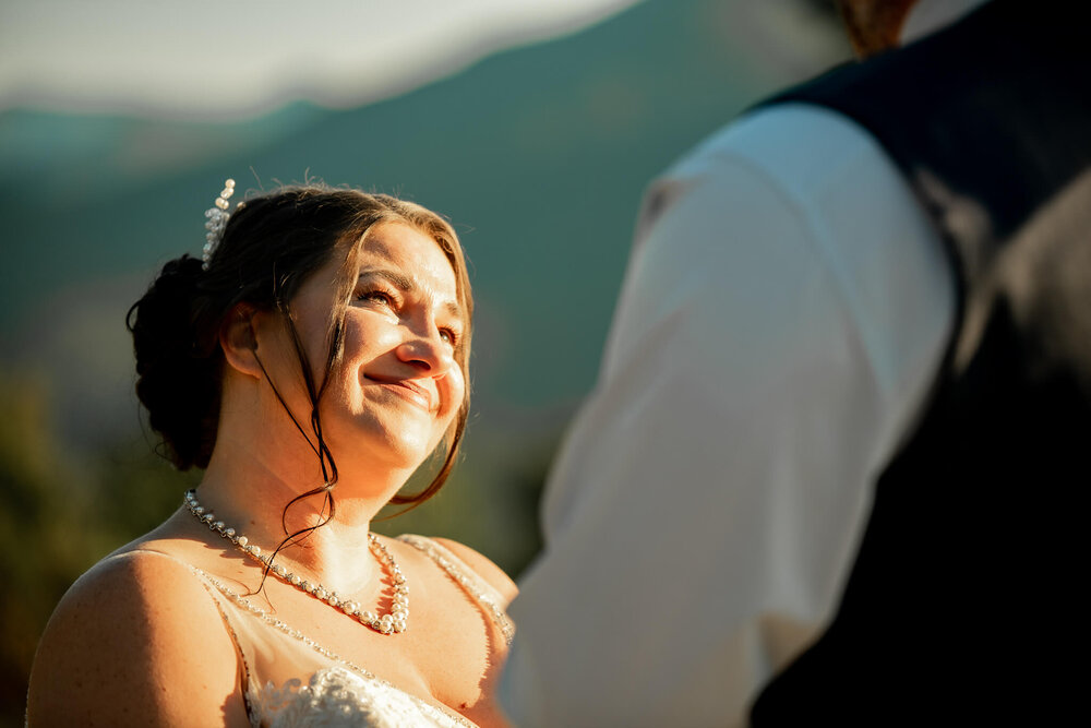 Bride looking up at groom during golden hour at mountain venue The Parker Mill