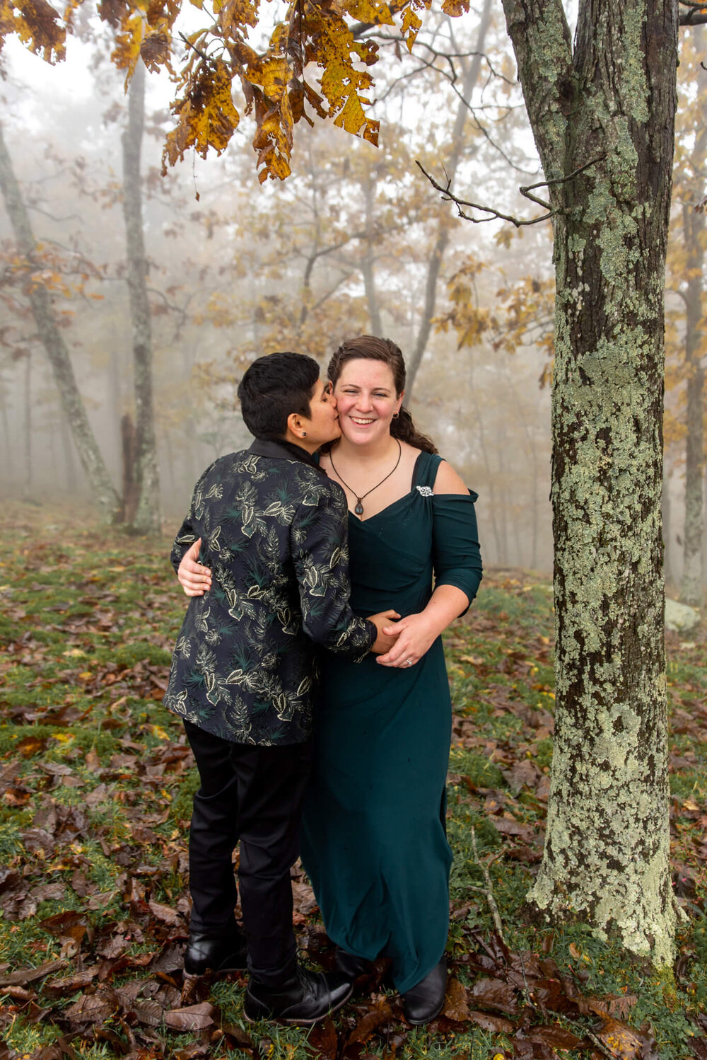 bride kissing her bride on the cheek at their bearwallow mountain elopement by nick levine photography