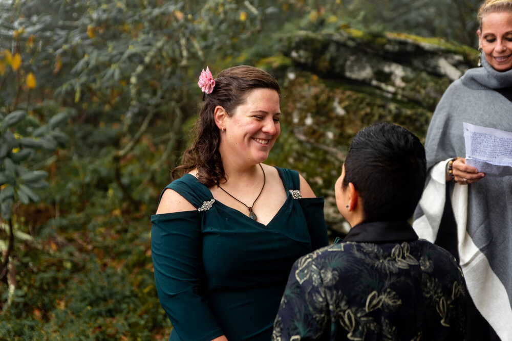 Bride smiling and looking at her bride during the elopement wedding ceremony in the mountains of WNC