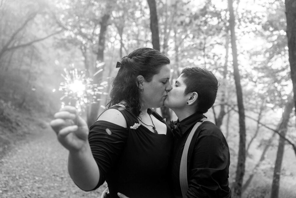 adventure elopement couple kissing while holding a sparkler during their reception