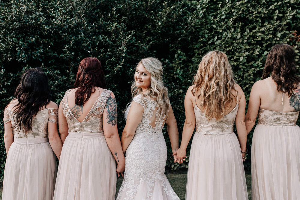 bride and bridesmaids outside posing together before their wedding at the gassaway manstion