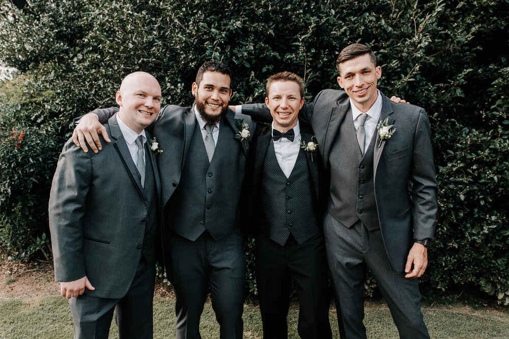 groom and groomsmen outside posing together before their wedding at the gassaway manstion