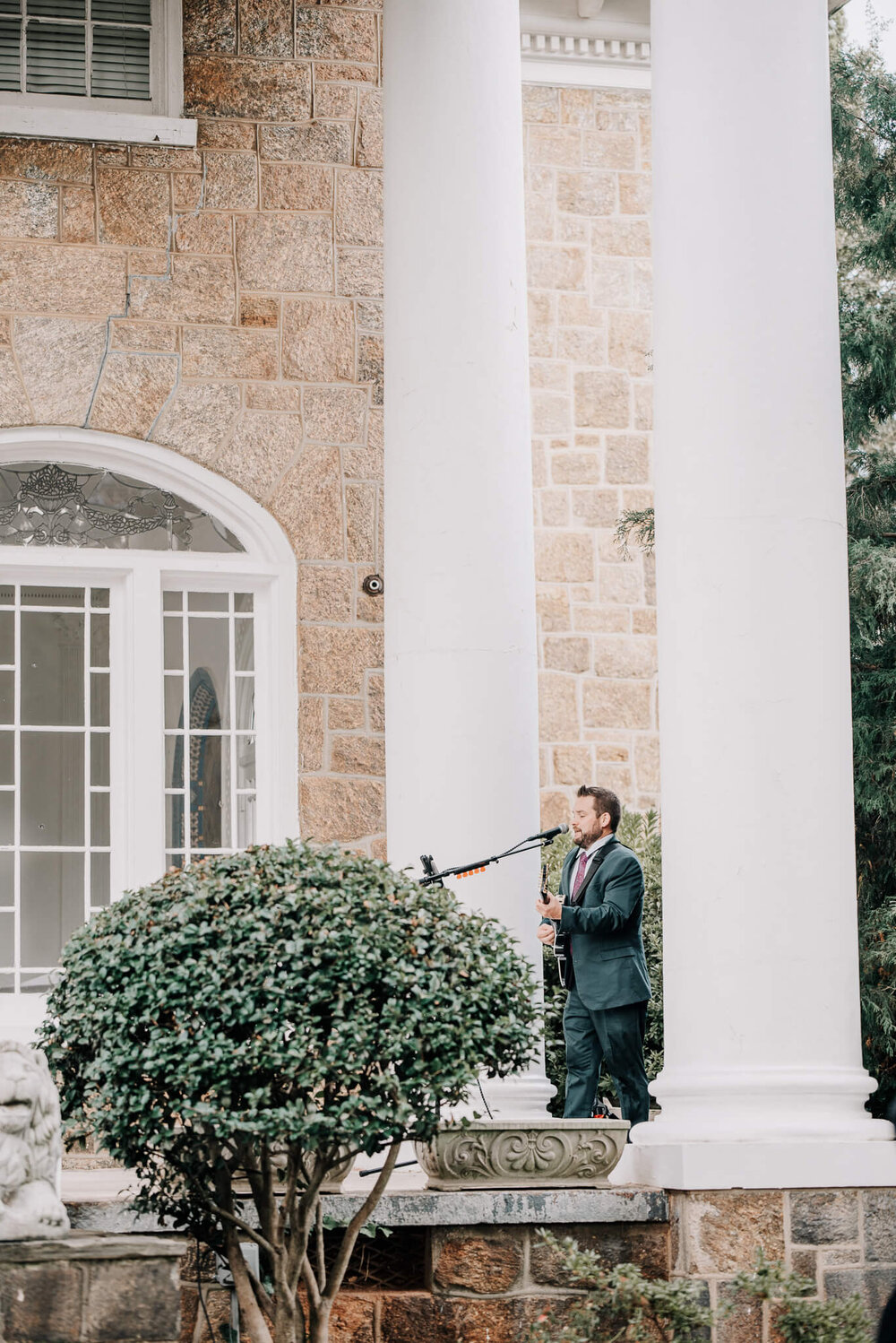 live musician for wedding ceremony on the front porch of the gassaway mansion playing the guitar and singing