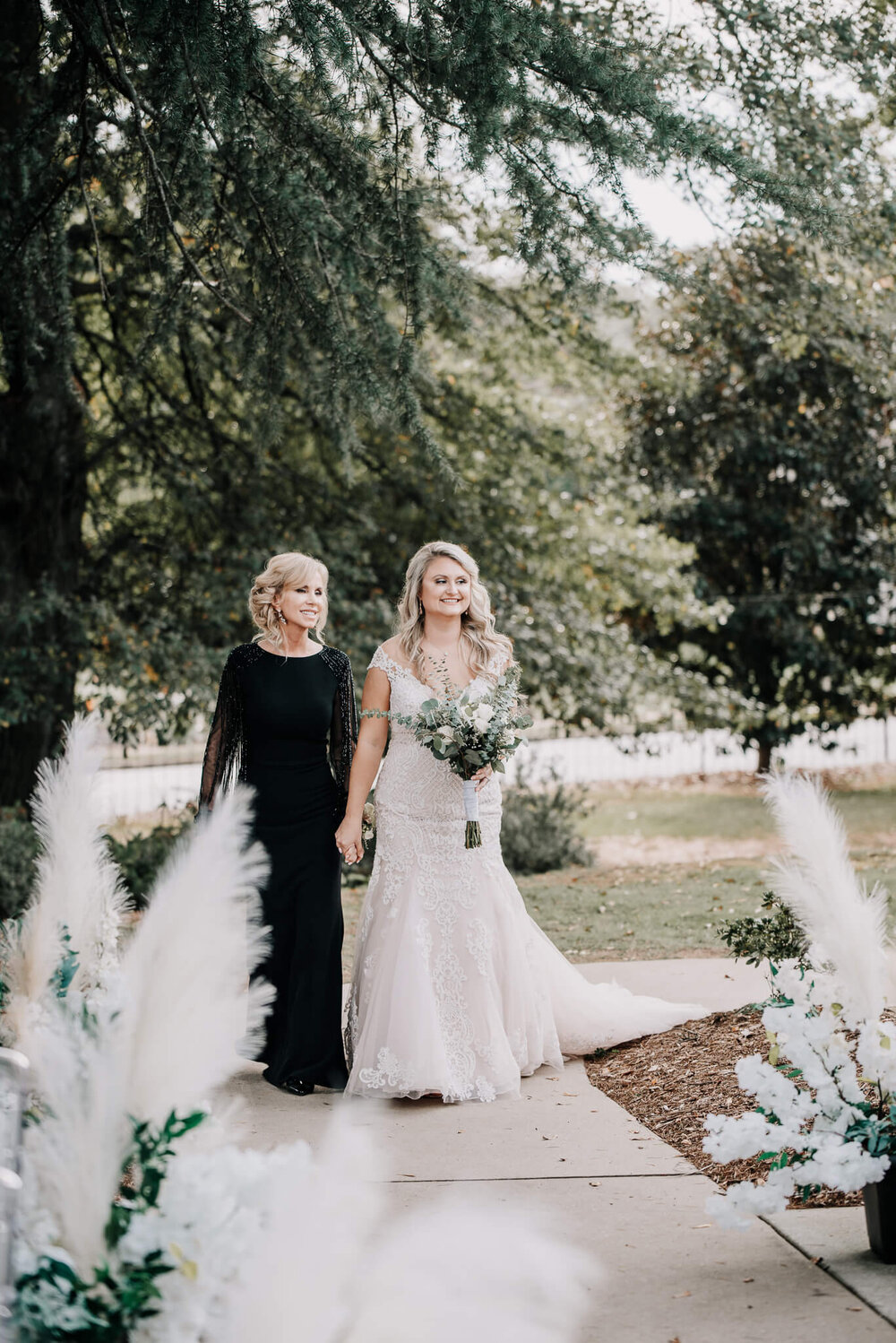bride and her mother walking down the aisle during her wedding at the gassaway mansion