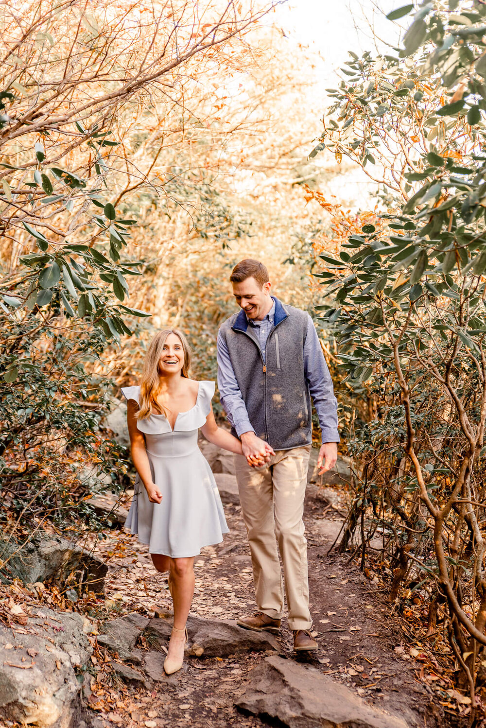 engaged couple walking through the forest during their fall engagement session with nick levine photography