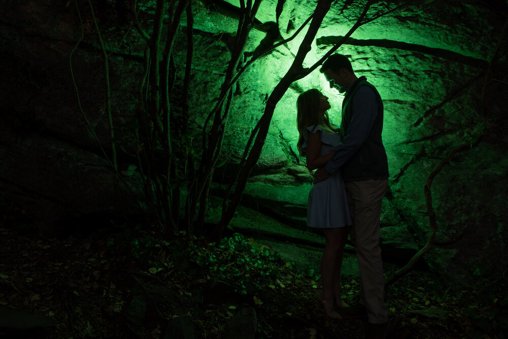 creative engagement photo with green light behind the couple as a sillouette