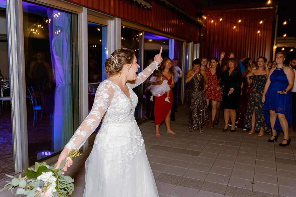 bride doing bouquet toss at the capital club of asheville photographed by asheville wedding photographer nick levine photography