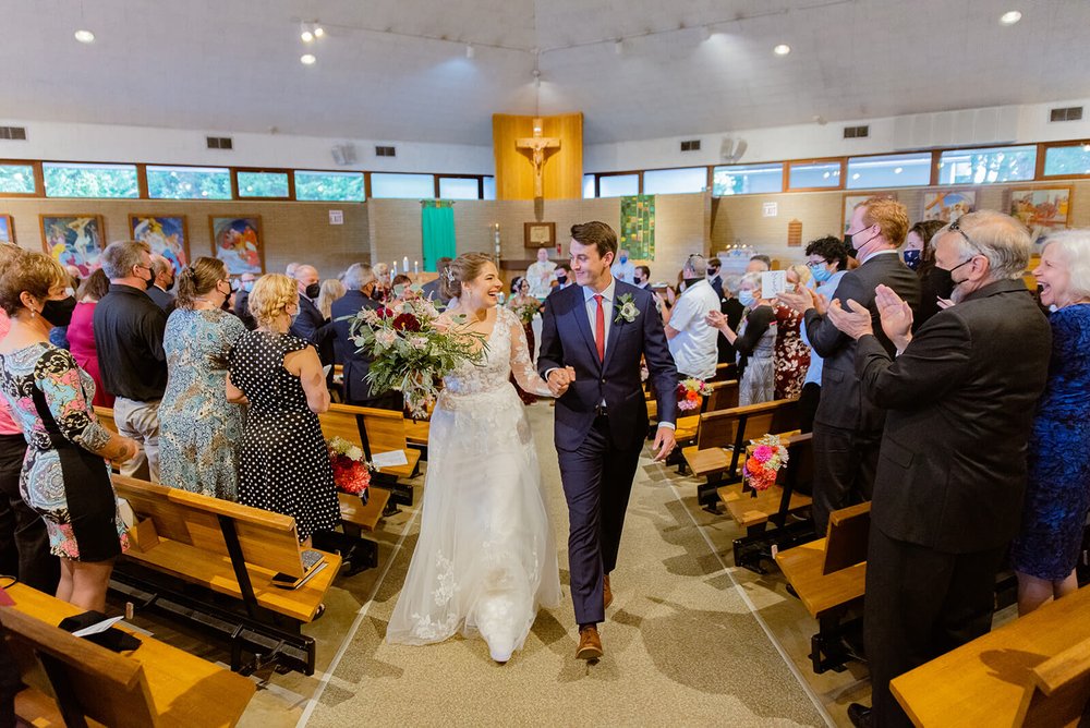 Wedding couple walking up the aisle after their wedding at st. eugene catholic church in asheville nc