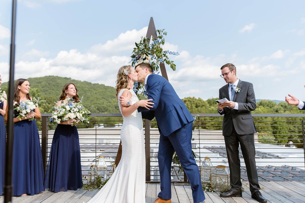 bride and groom first kiss at highland brewery wedding venue in asheville north carolina