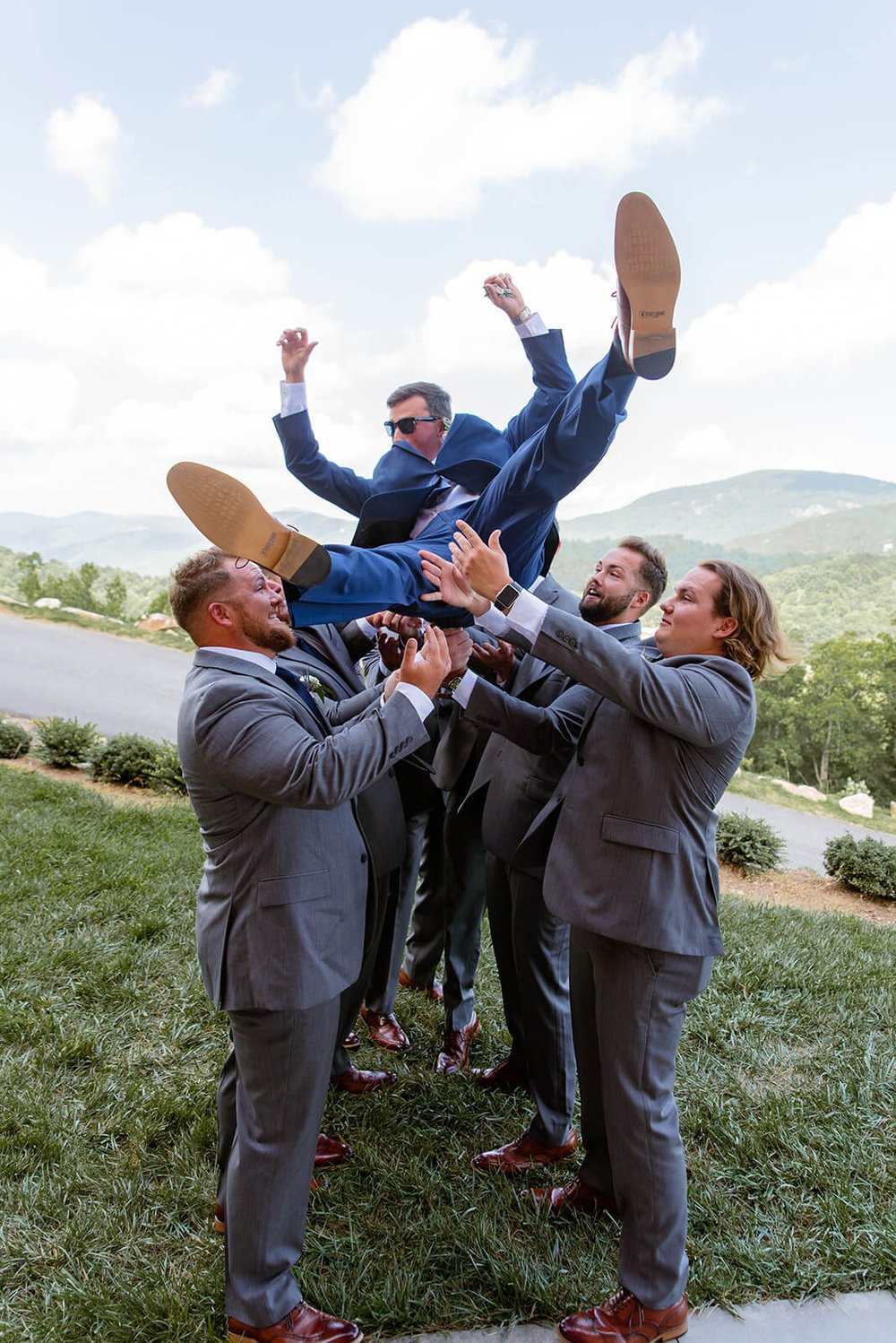 tossing groom in the air at point lookout vineyards wedding venue