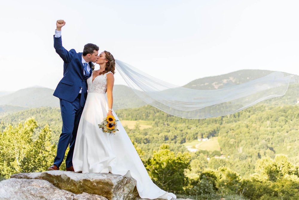wedding couple kissing on epic mountaintop at point lookout vineyards