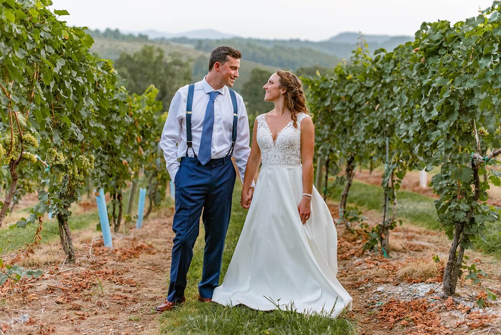 wedding couple in the vineyards at point lookout vineyards wedding venue in hendersonville nc