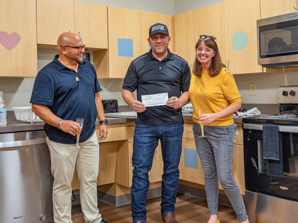  Jeff Brawley from Bloomington Board of Realtors (center), accompanied by Chris Cockerham (left), presents a check to New Hope for Families Executive Director Emily Pike (right) as part of BBOR’s support of the New Hope expansion and relocation campa