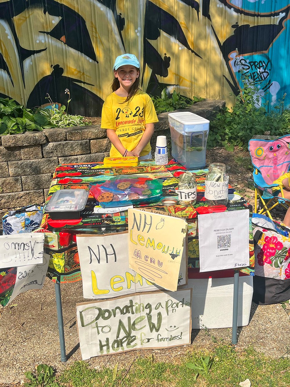  Annelise Dilger works at her lemonade stand as part of Lemonade Day in Monroe County on Saturday, June 24, 2023. along the B-Line Trail in Bloomington. A sign reads “Donating a portion to New Hope for Families!” 