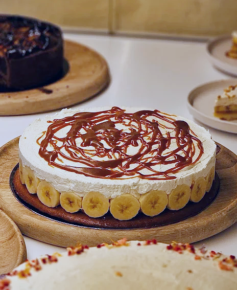 Gâteau avec bananes autour, garniture blanche et caramel en decoration