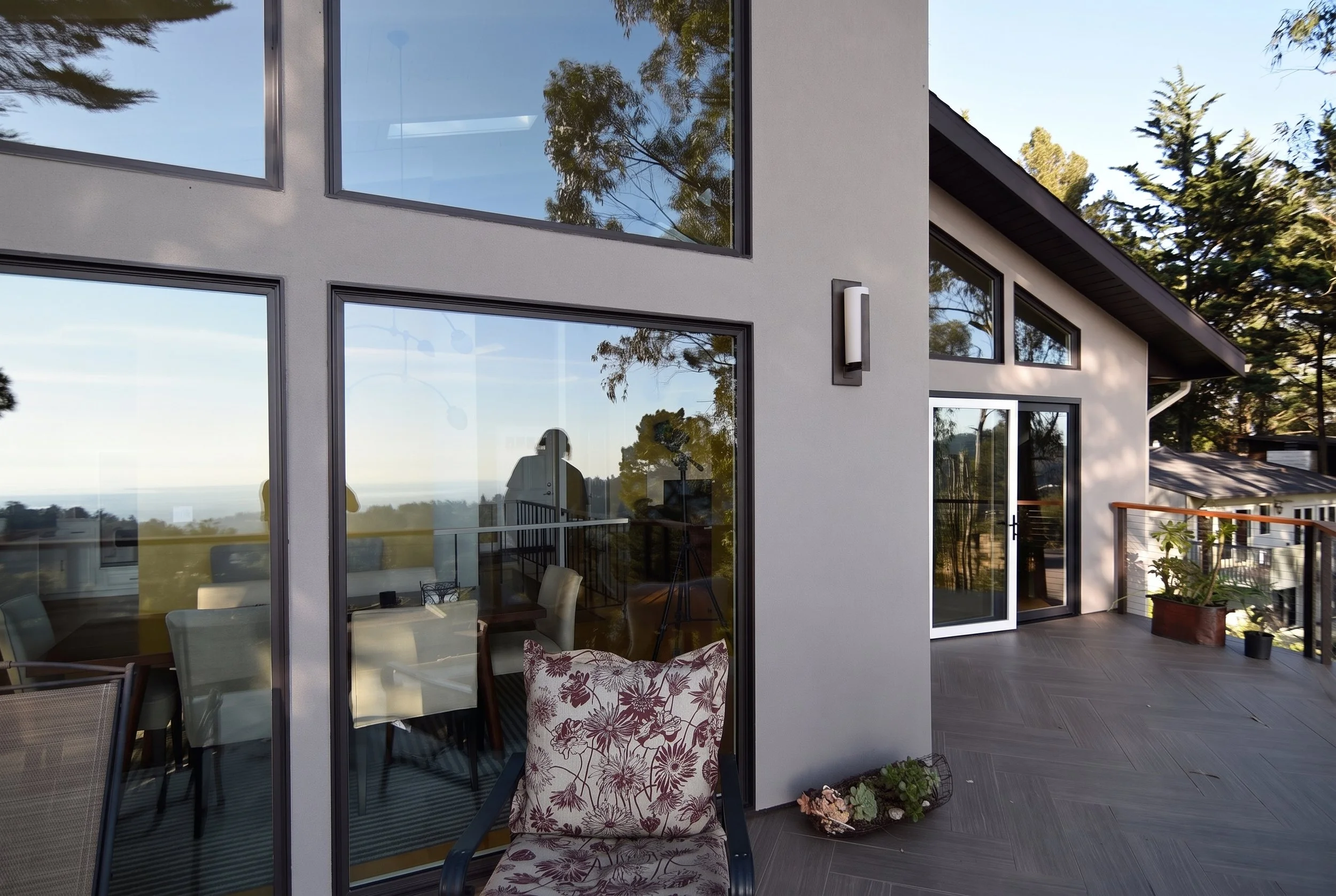 Floor-to-ceiling glass walls and sliding doors facing the deck.