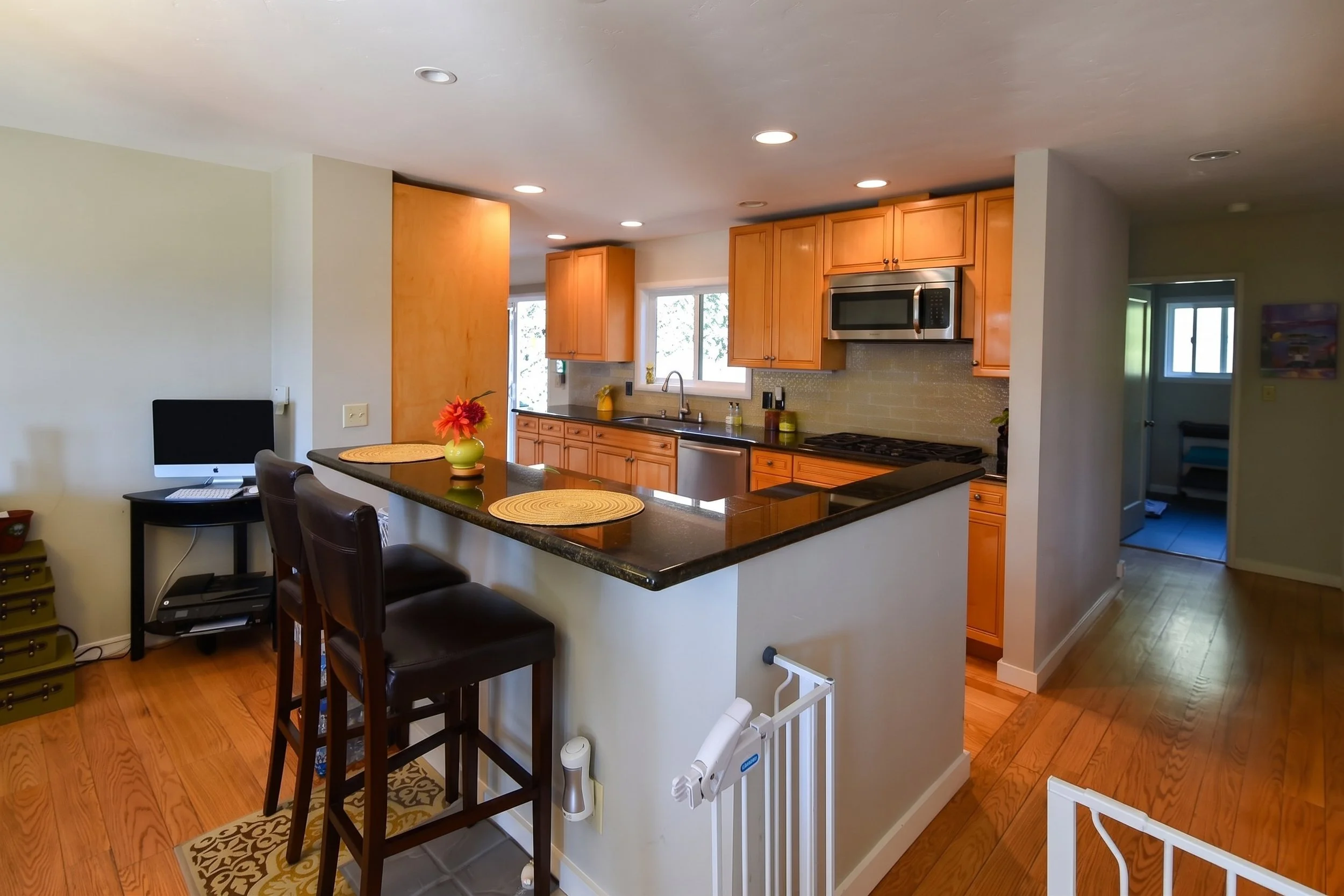 Kitchen opened to the living area with a peninsula bar and stools.
