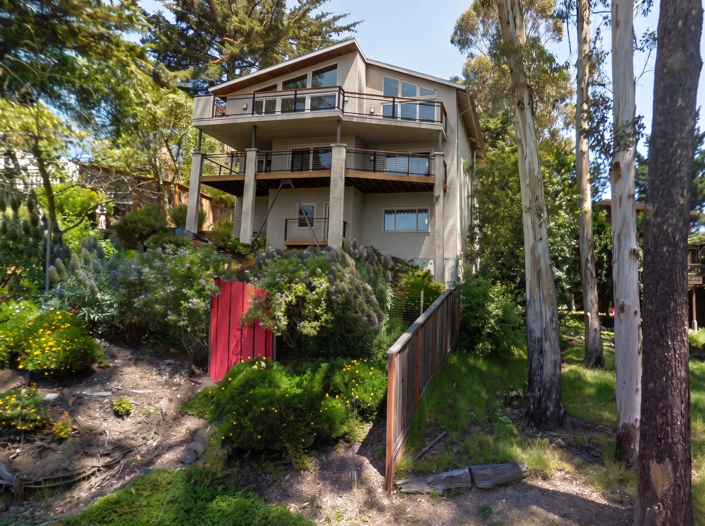 The house and its decks seen from below on the hillside.