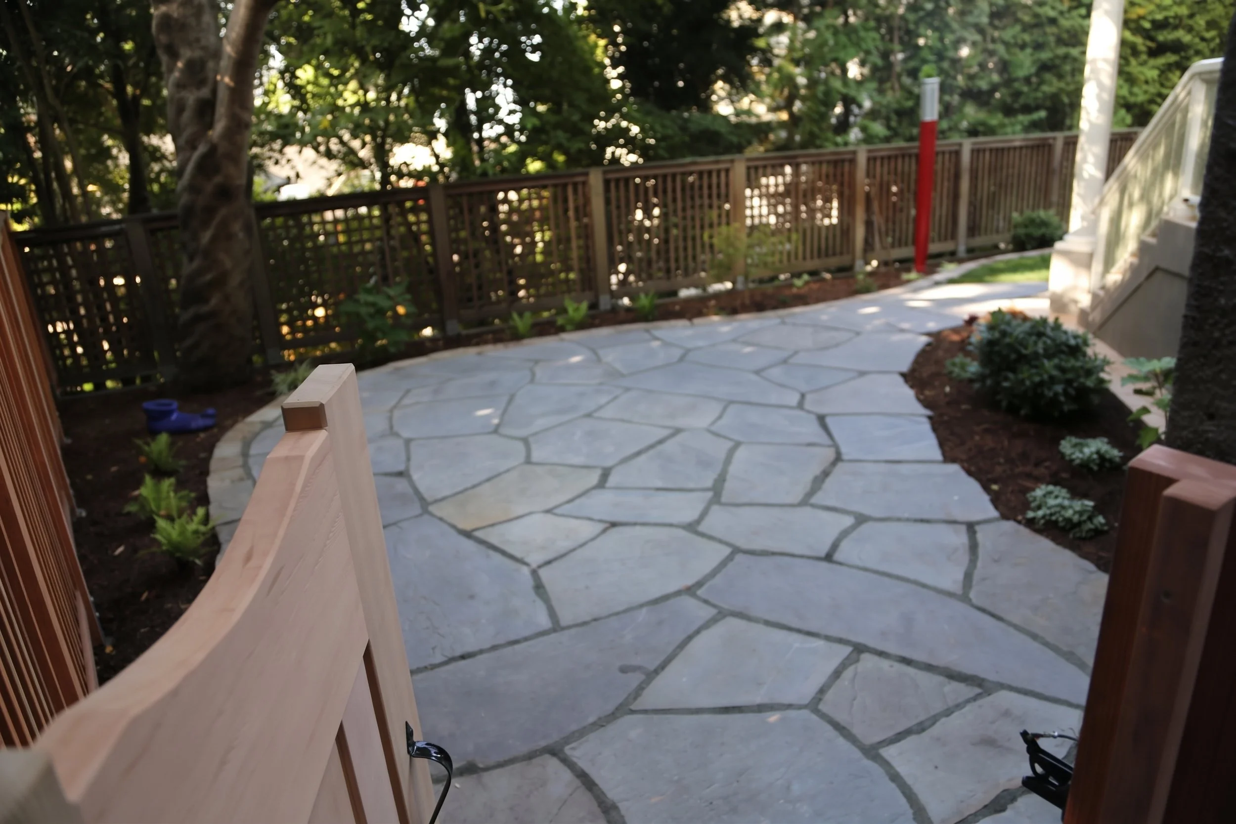 Flagstone paving leading to a wood gate.