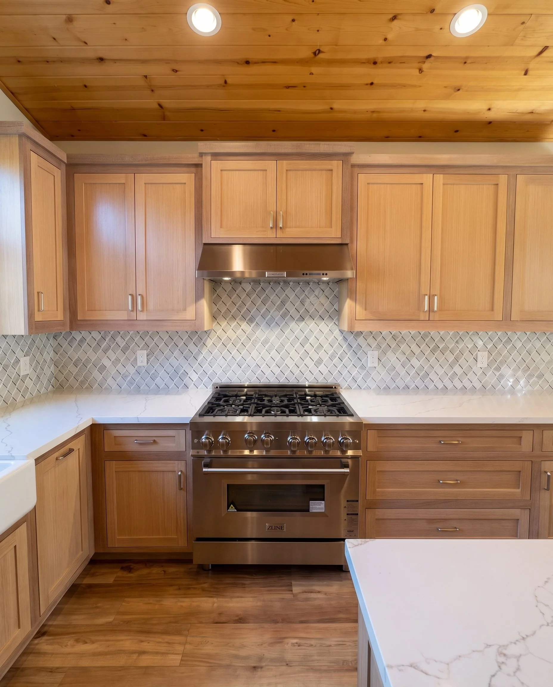 Range wall with a stainless hood and an arabesque tile backsplash.