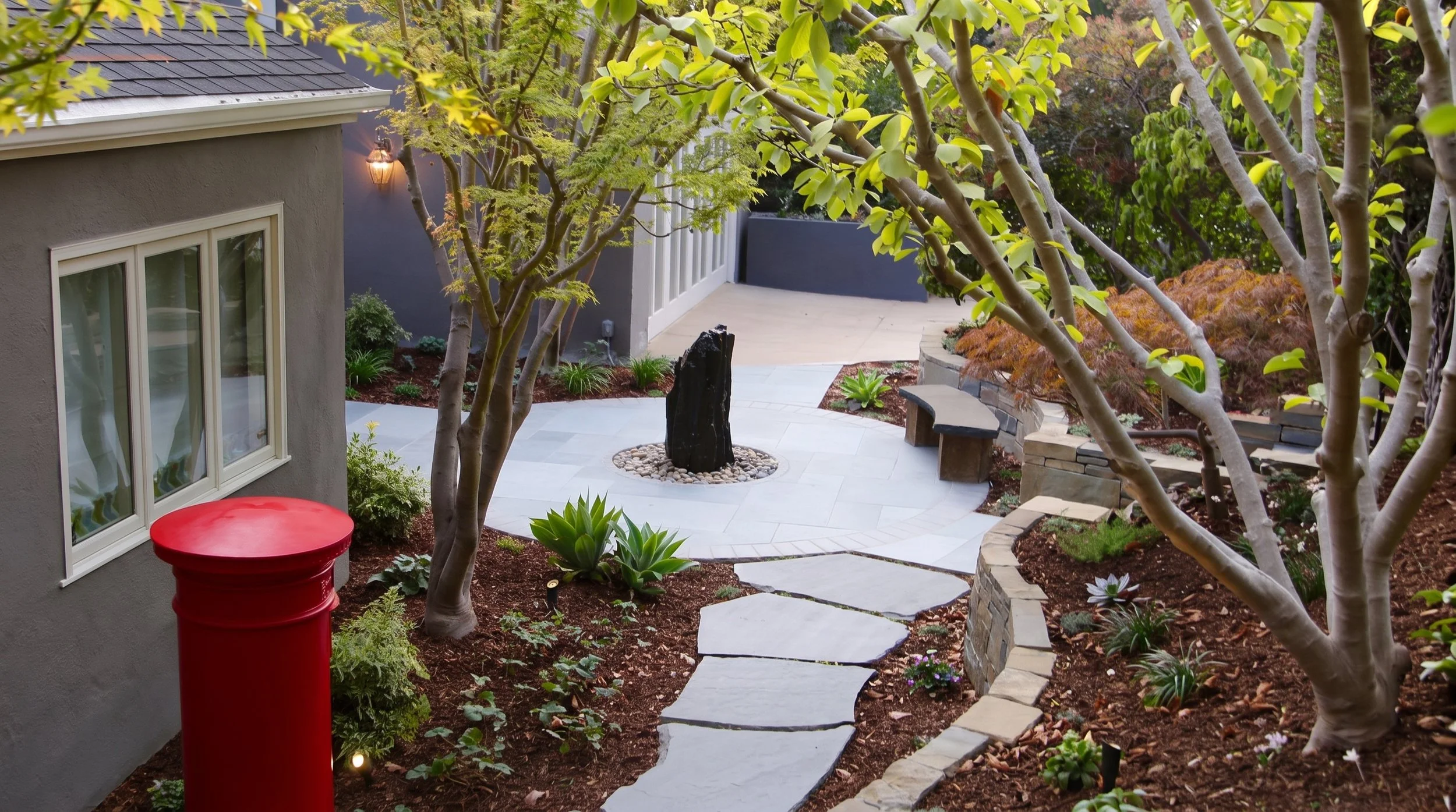 Flagstone path past a small building with a red post box.