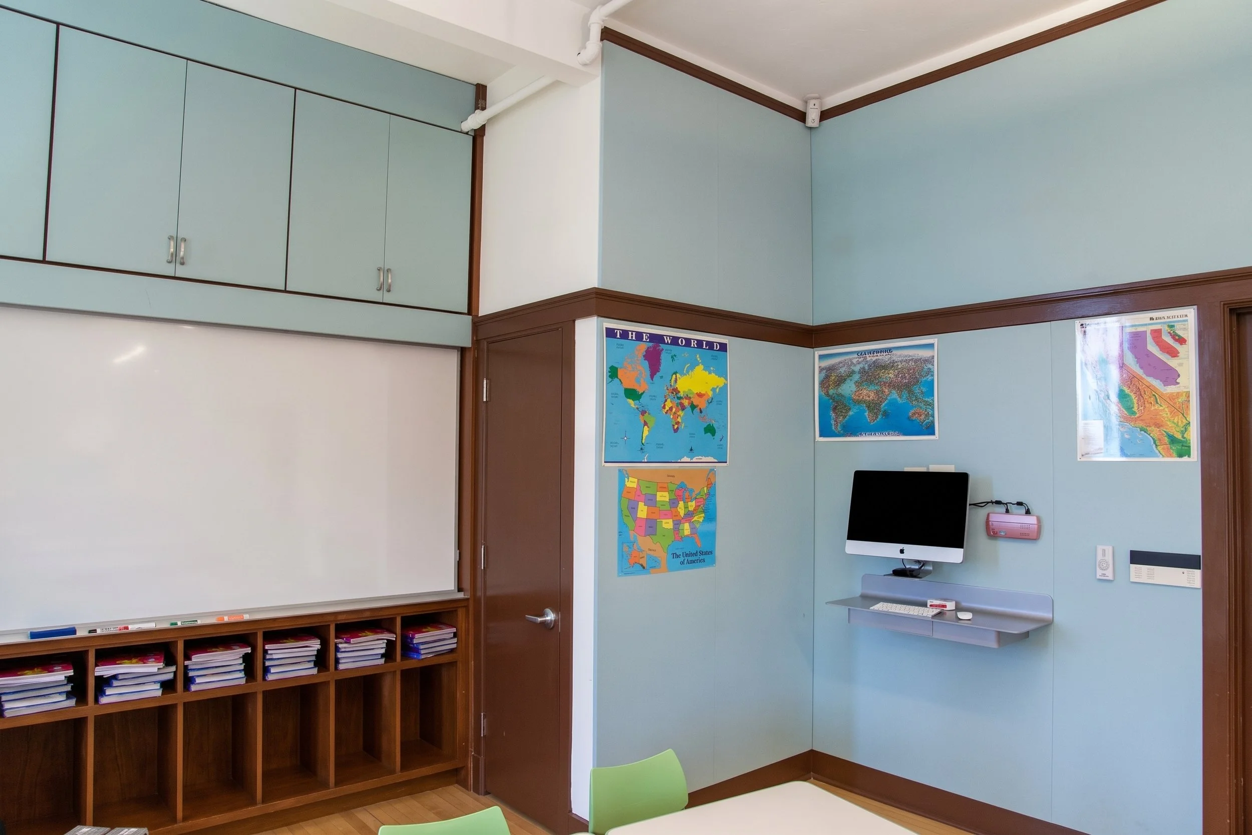 Cubbies below the whiteboard and a wall-mounted computer station.