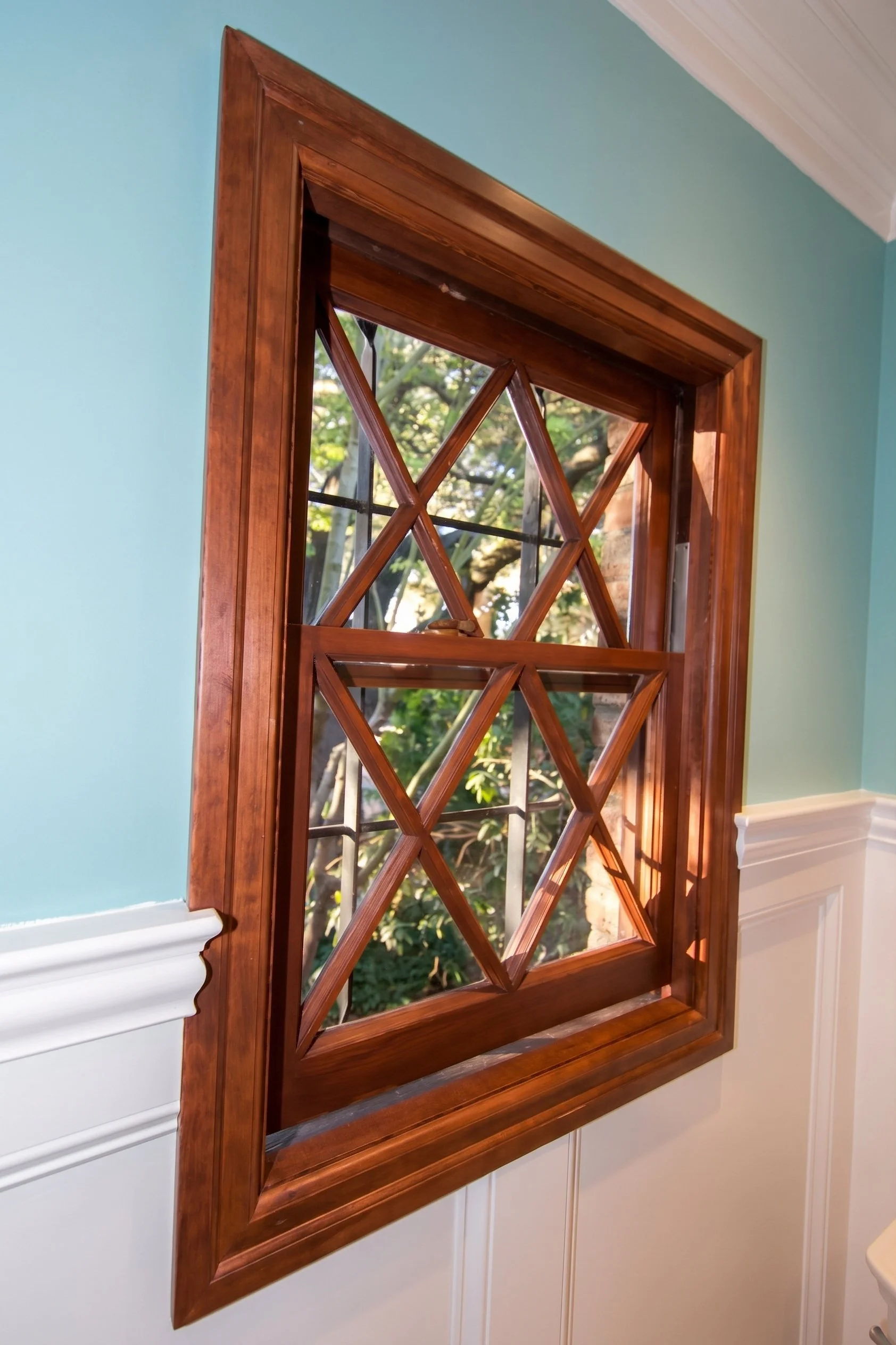 Original diamond-pane wood window above the paneled wainscot.