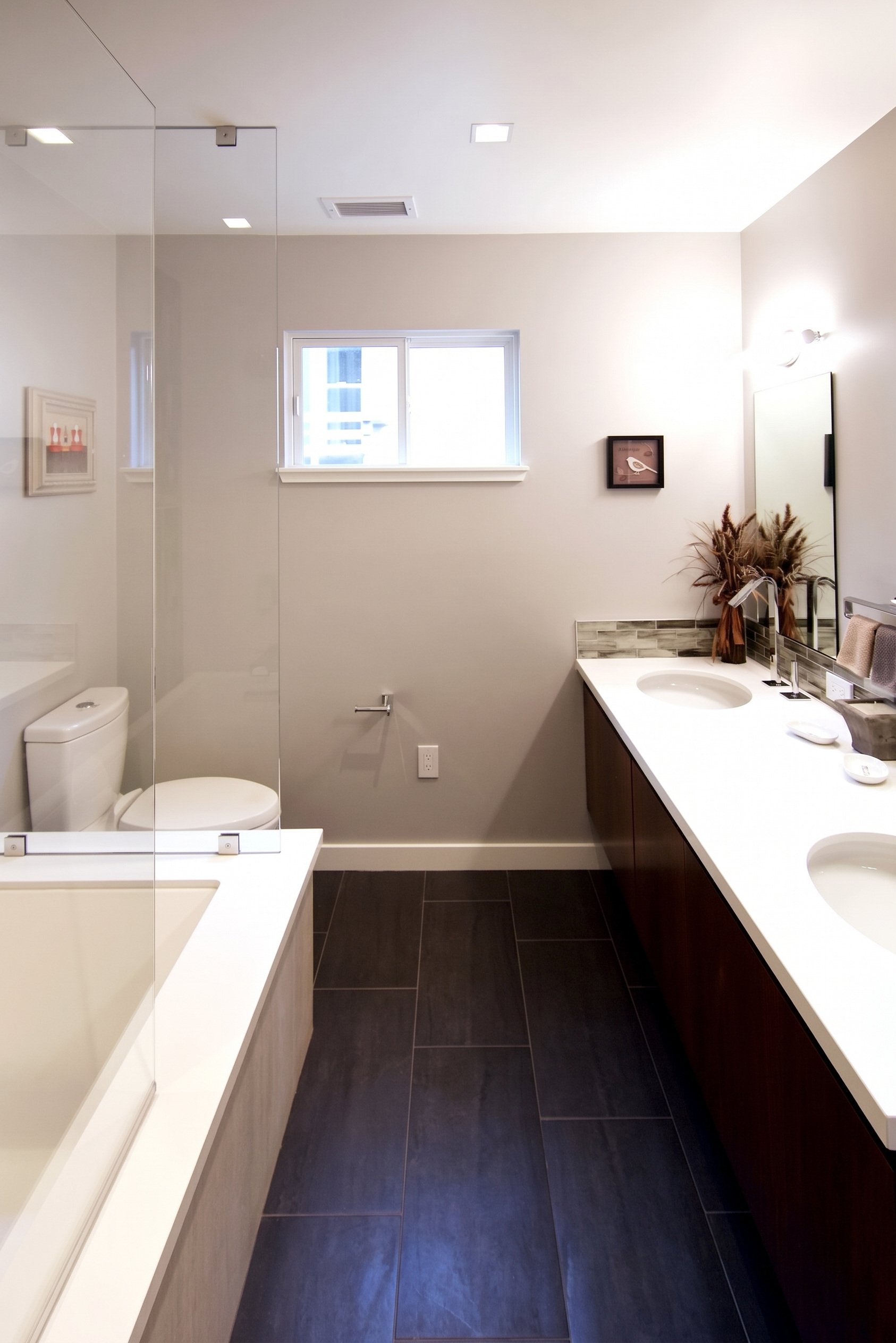 Bathroom with a dark floor, a vanity and the tub.