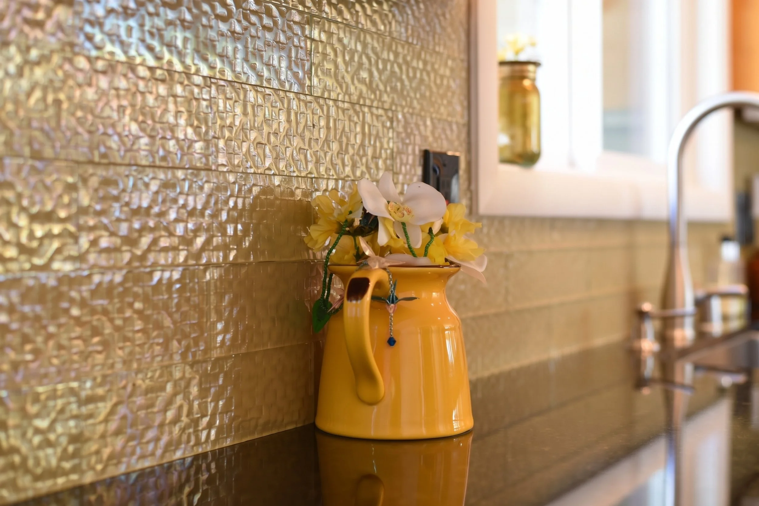 Textured tile backsplash behind the sink.