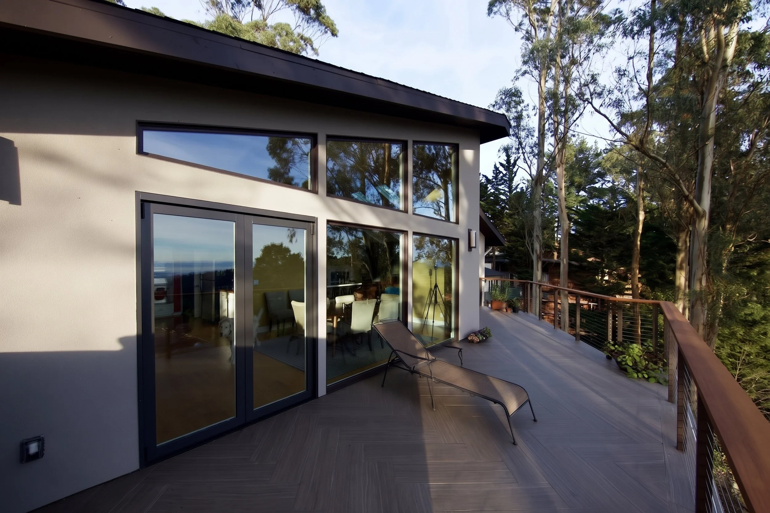 Upper deck running along the addition, with a cable railing.