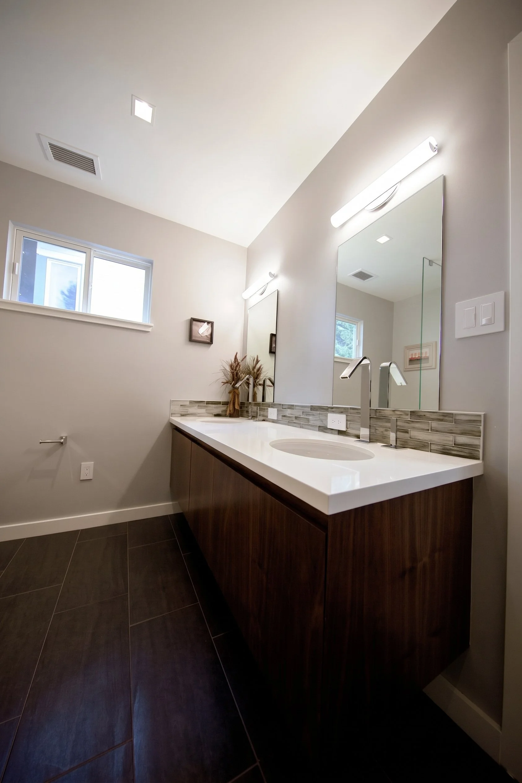 Dark wood vanity under a tall mirror.