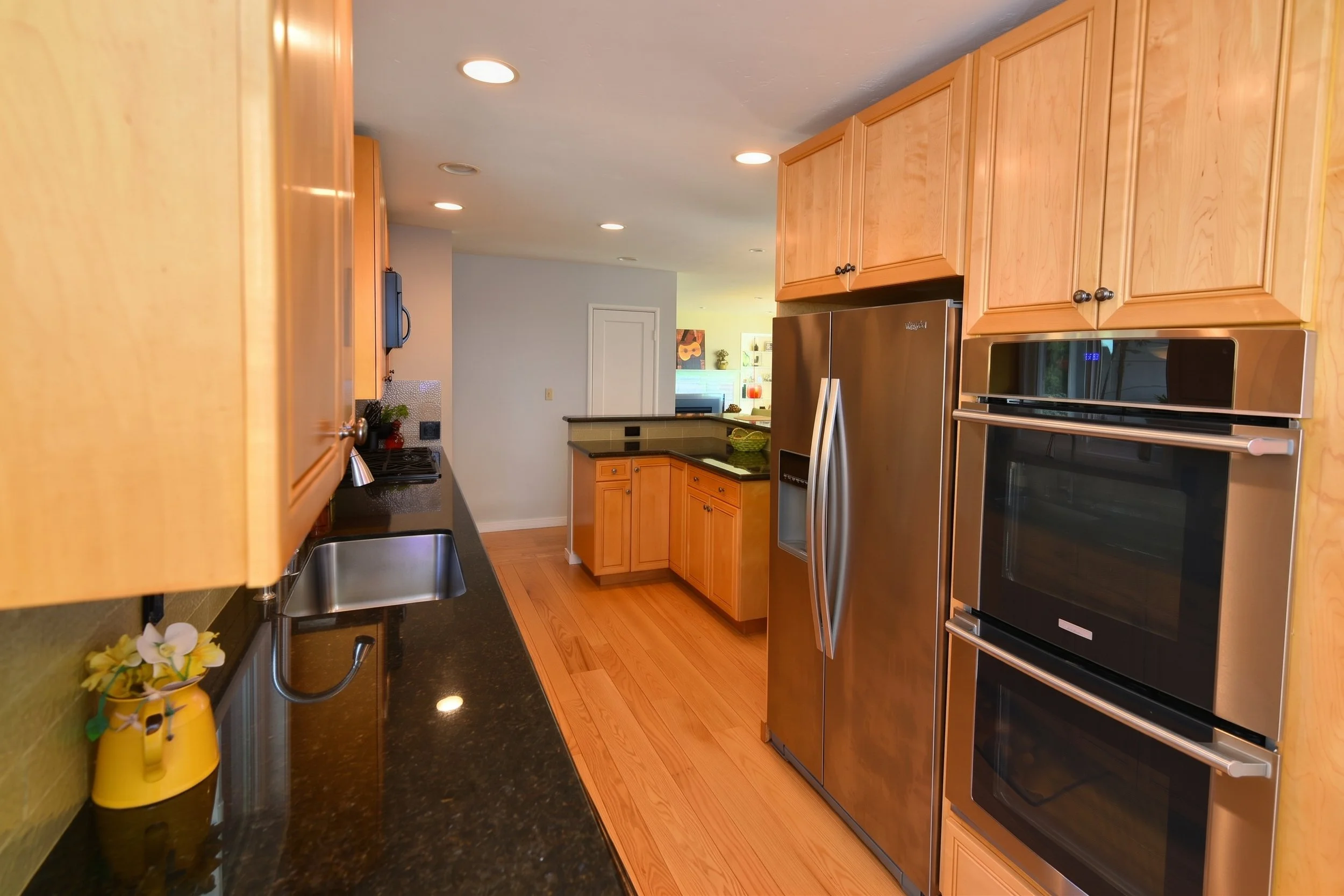 Kitchen counter and wall ovens seen across the peninsula.