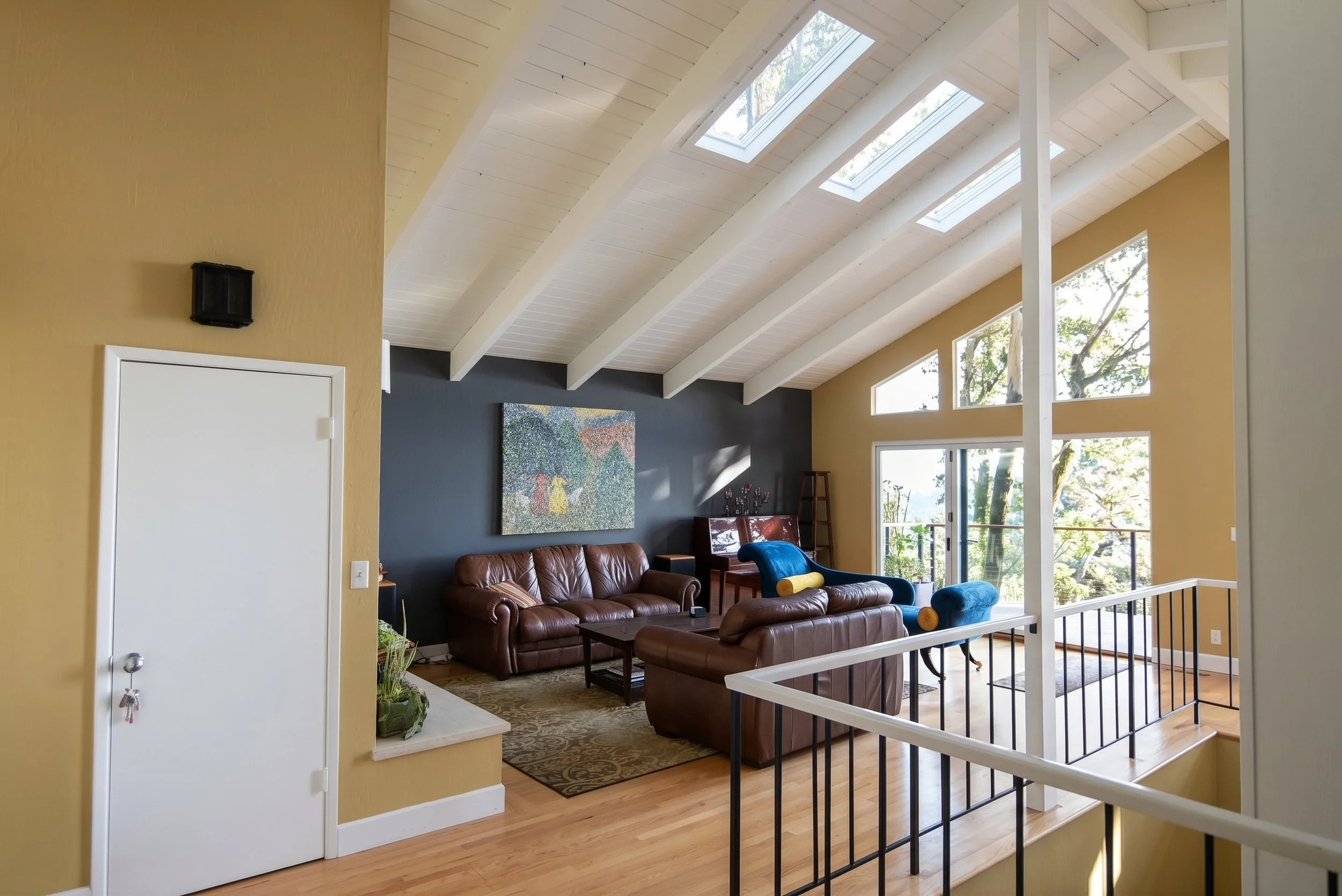 Living room in the addition with skylights and a wall of angled windows.
