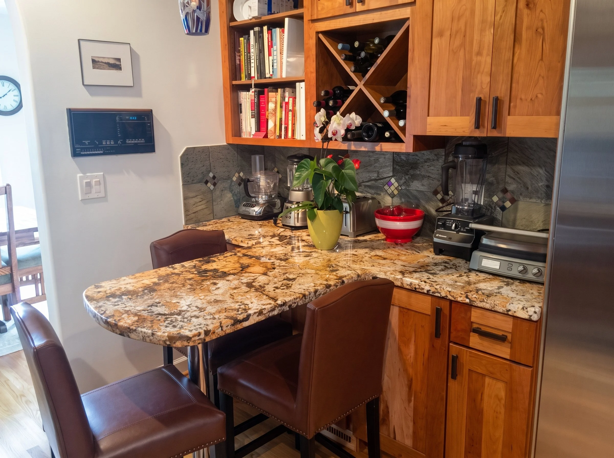 Stone counter corner with cherry cabinets, wine storage and open shelves.