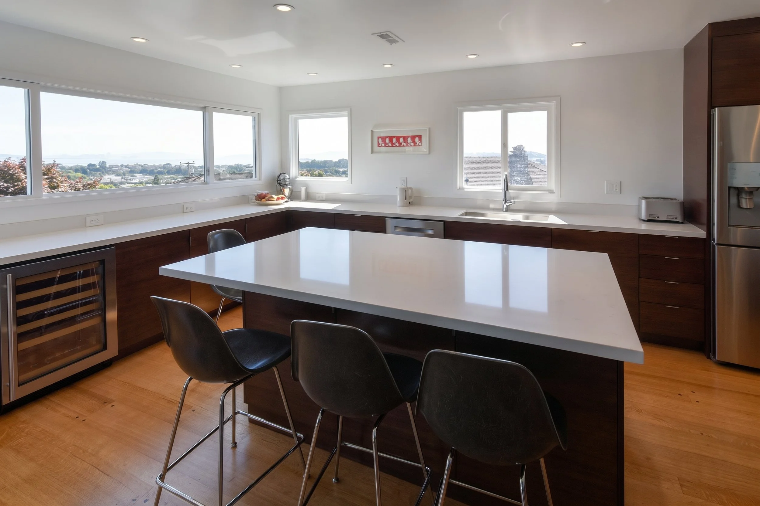 Kitchen island with seating under a band of view windows.