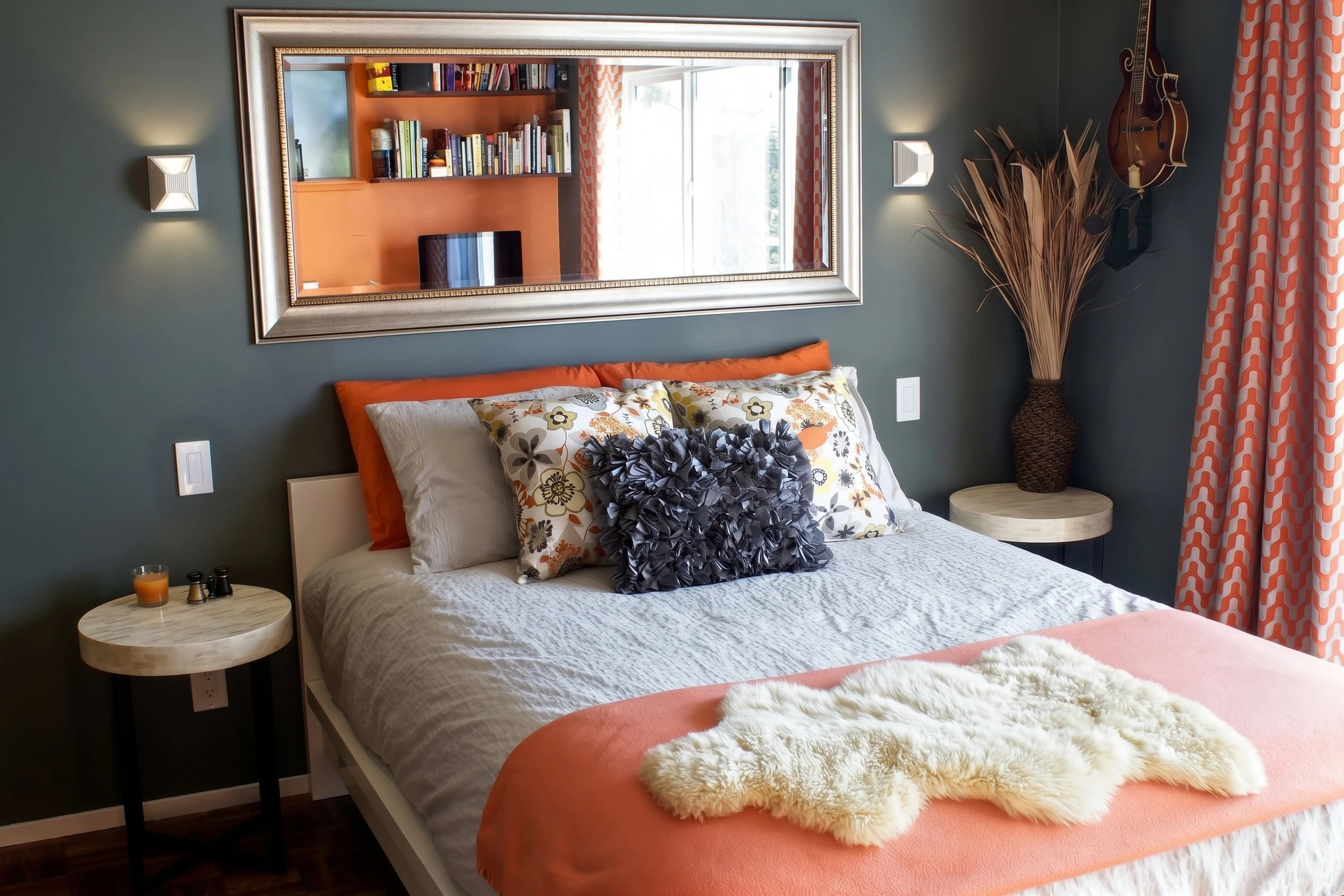 Bedroom with a gray accent wall and a framed mirror.