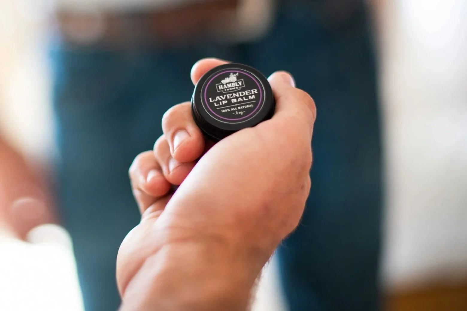 Man holding Hambly Farms Lip Balm in his palm ready to apply