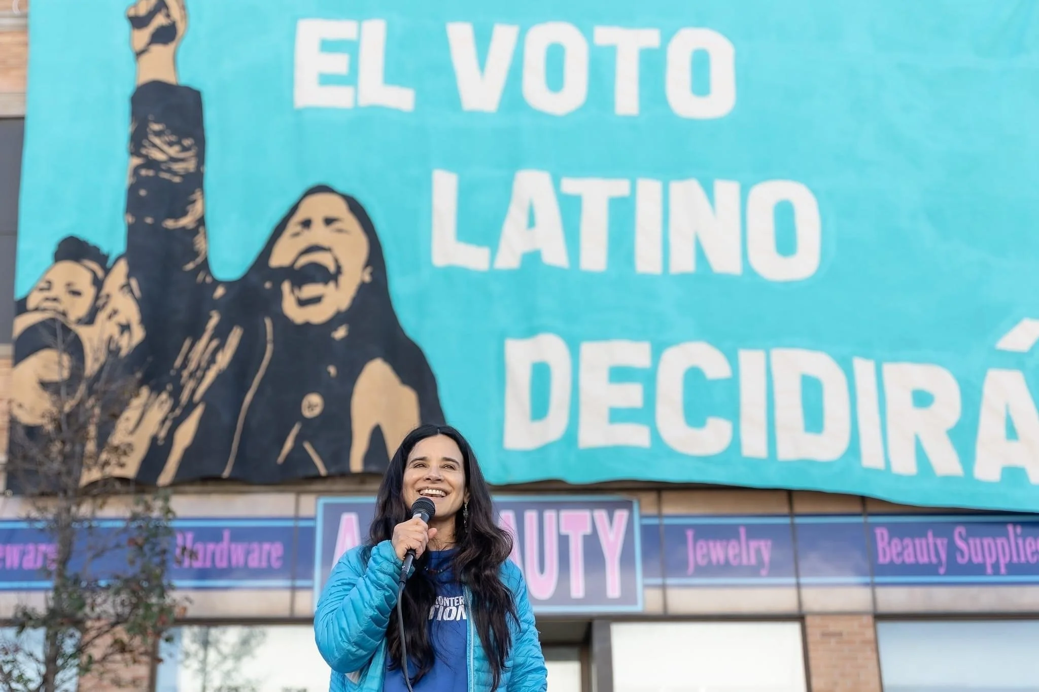  Voces de la Frontera. Banner drop infront of the Mitchell Street Voces Office for a GOTV effort for the midterm elections. October 2022. Voces Executive Director Christine Neumann-Ortiz speaking to the crowd.  