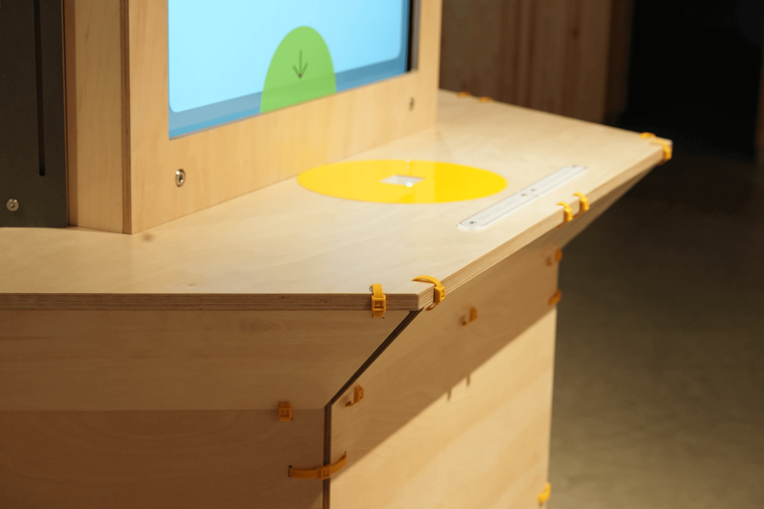 什器はアルミフレームの骨組みに合板を固定した構造で、板同士を黄色い結束バンドで結びつけたようなデザインになっています。