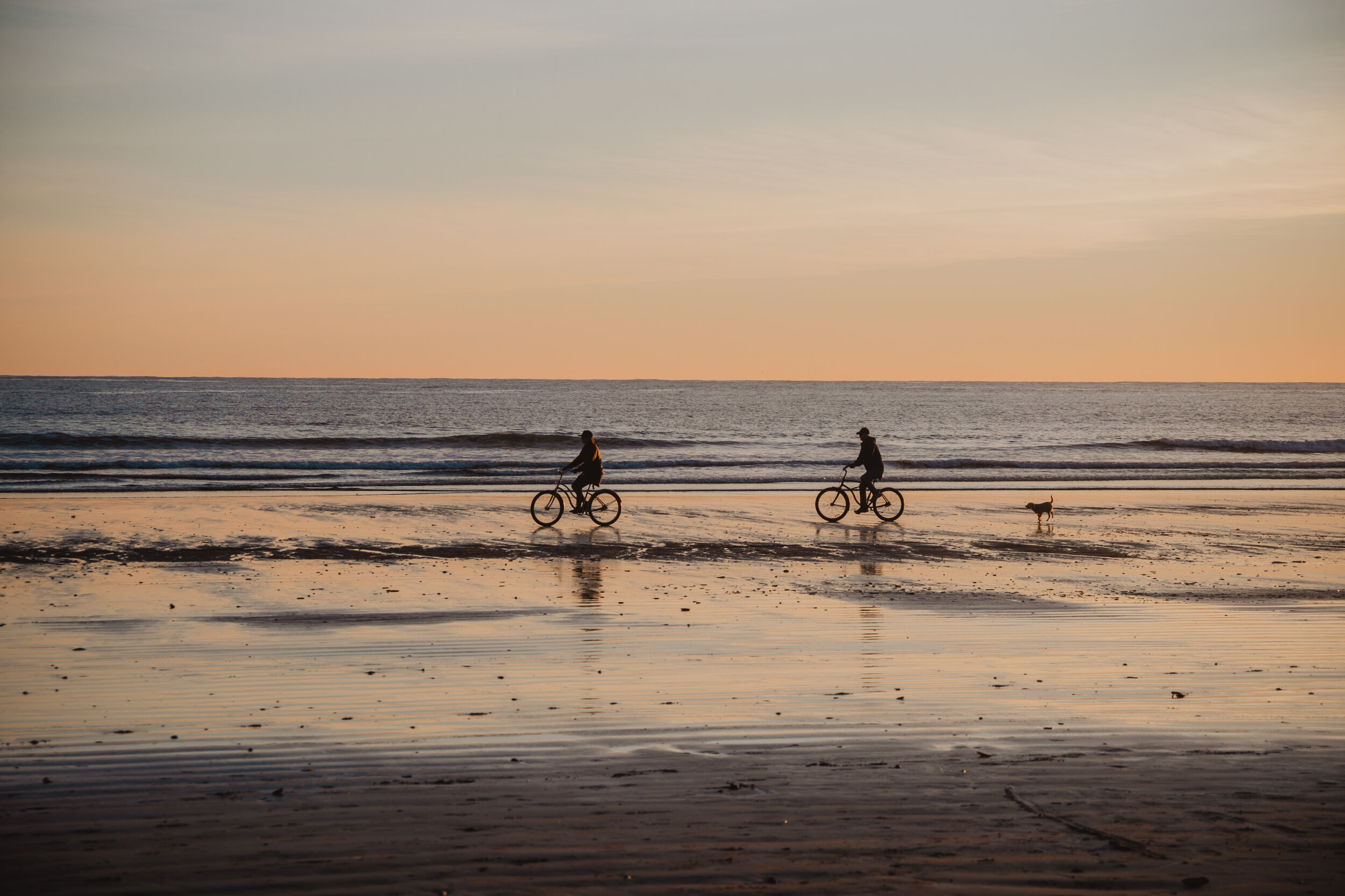 Biking along the beach at sunset in Tofino