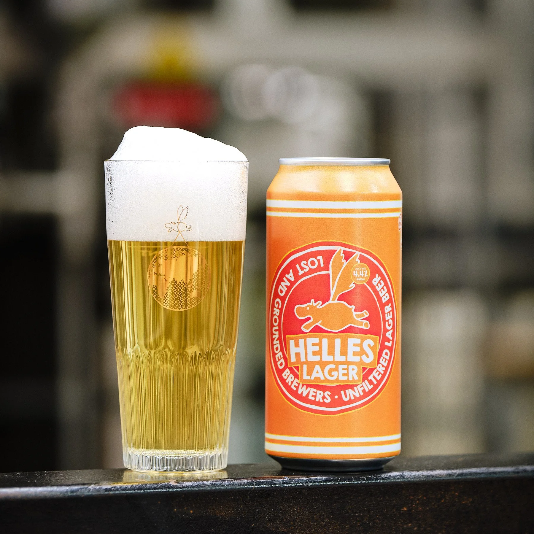 A can of Lost and Grounded Helles (Unfiltered Lager Beer 4.4%), next to a filled glass.