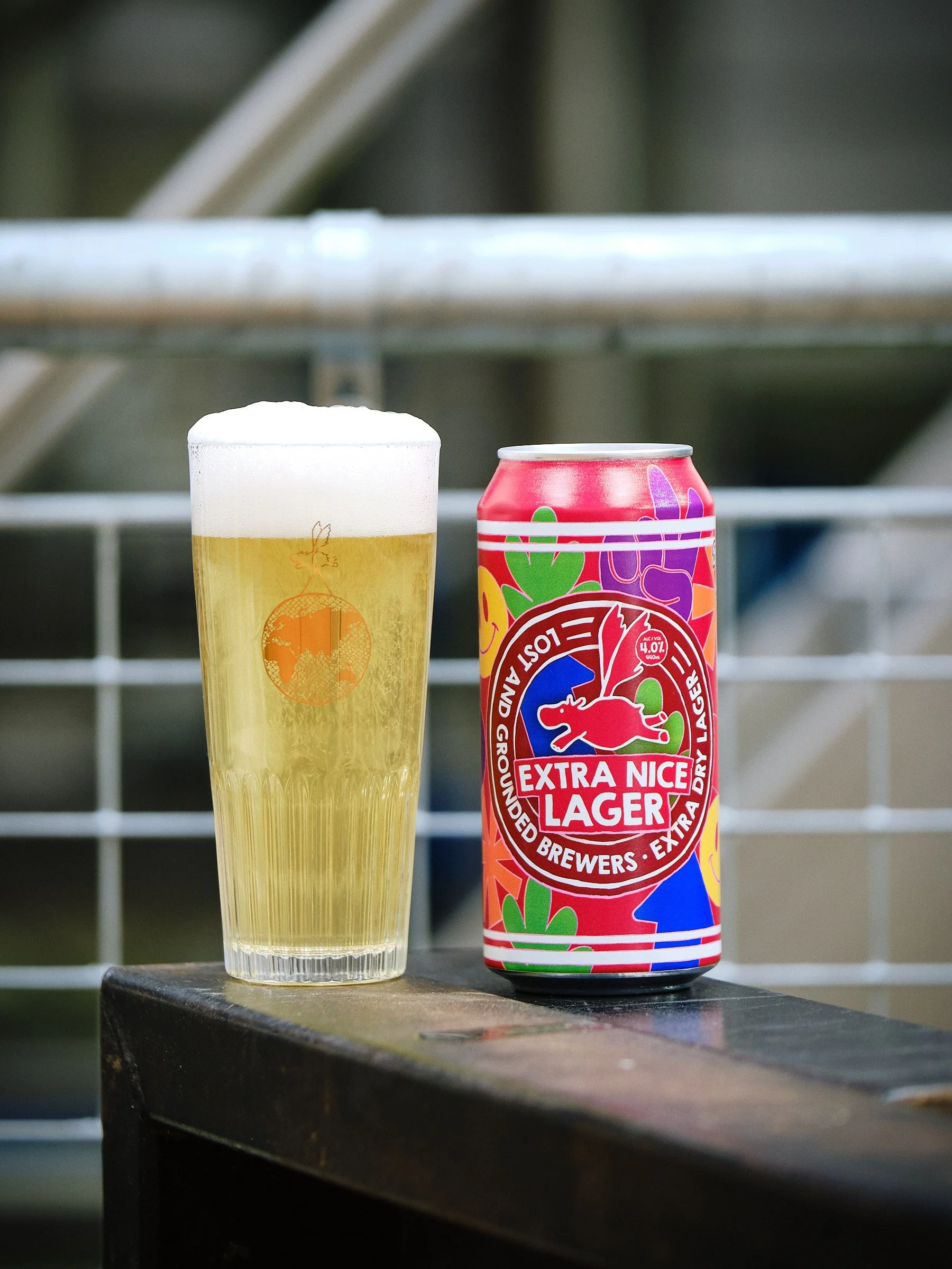 Extra Nice - 4% Extra Dry Lager next to a filled glass.