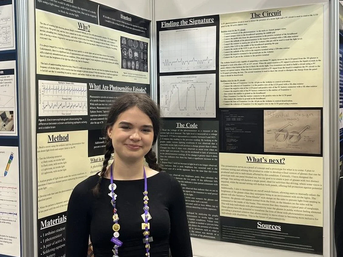 Syd West standing infront of her science fair board.