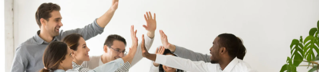 people in a workplace high-fiving each other