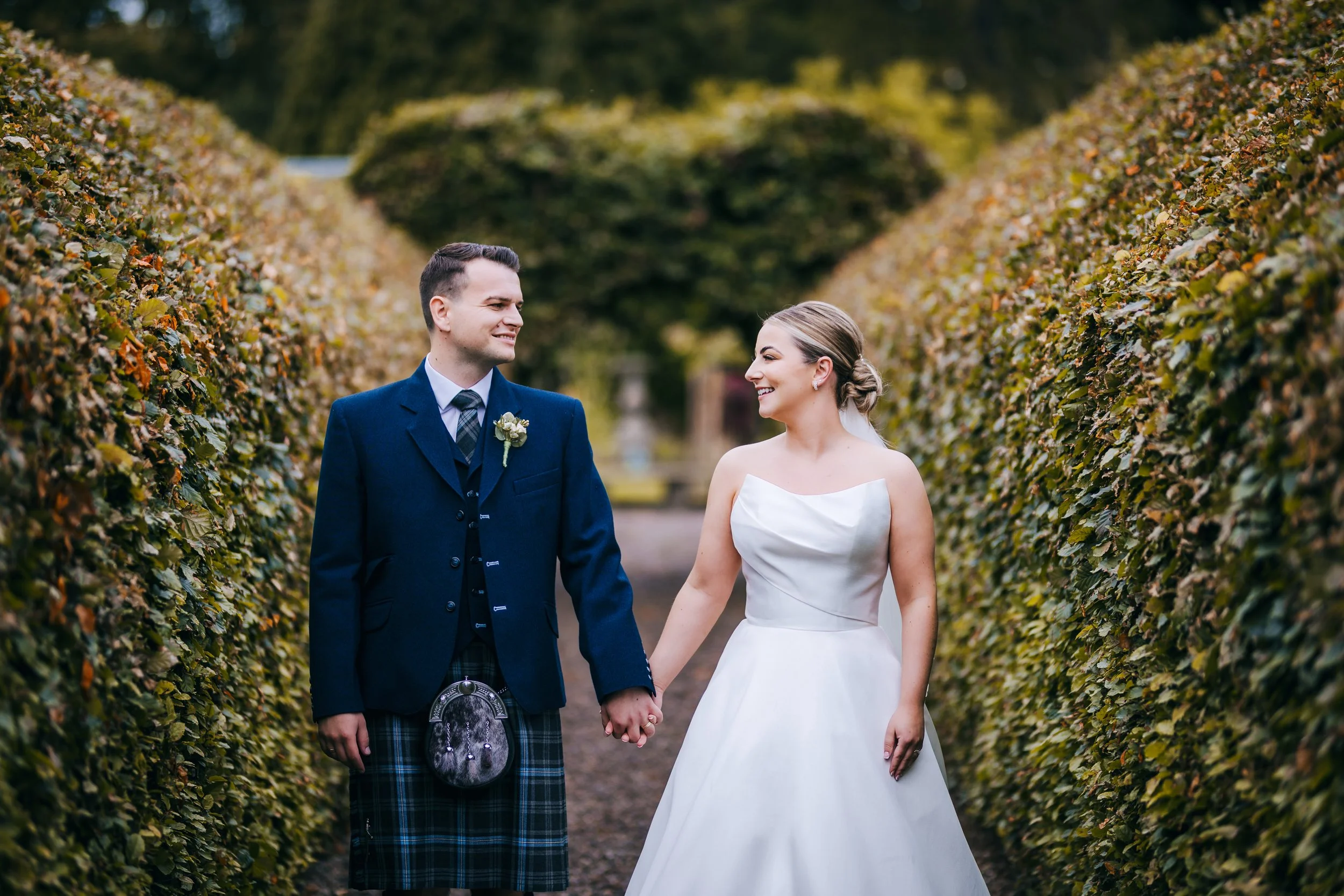 Stunning couple walking in the maze hedges at Errol Park