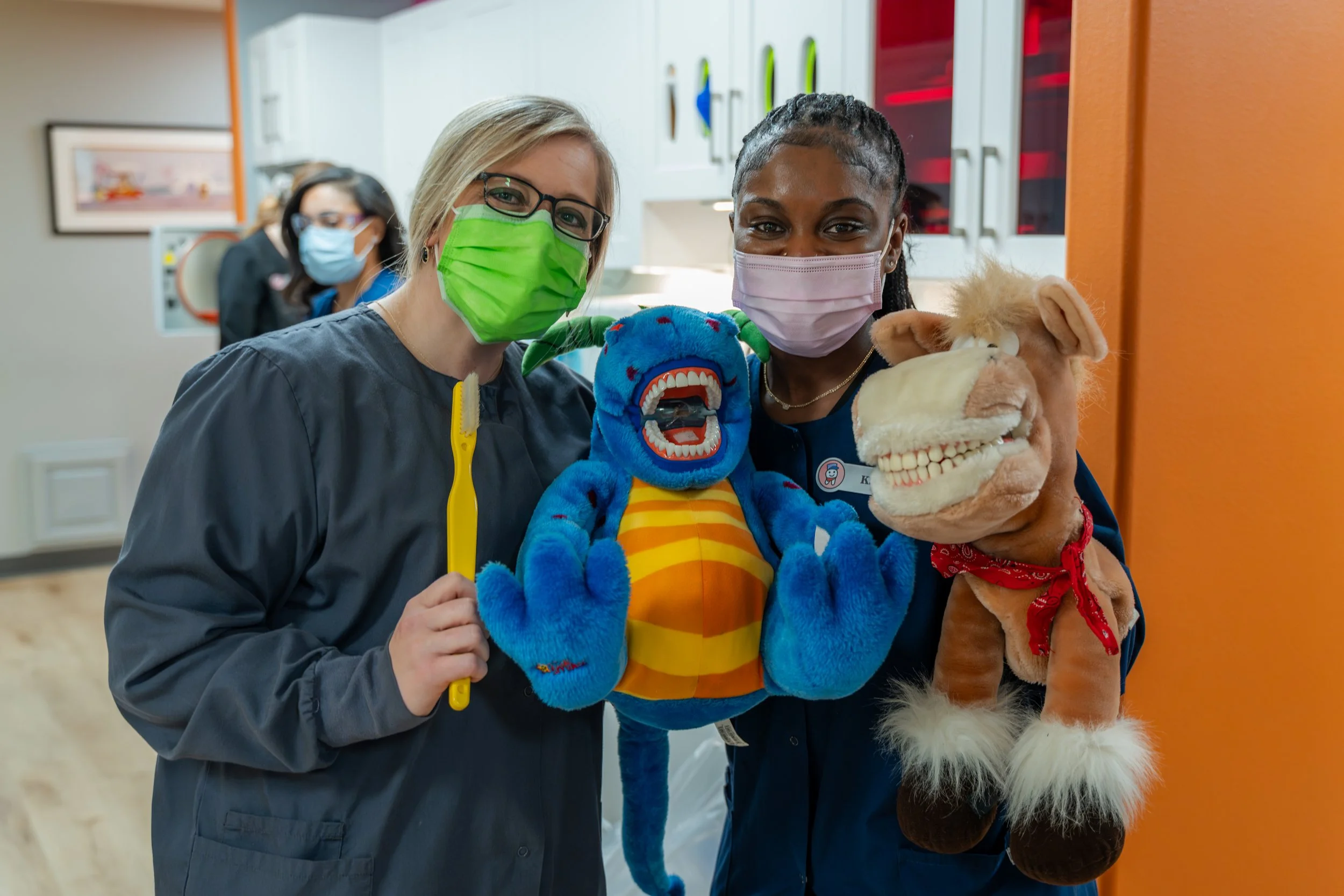 dental assistants demonstrating brushing techniques for all children